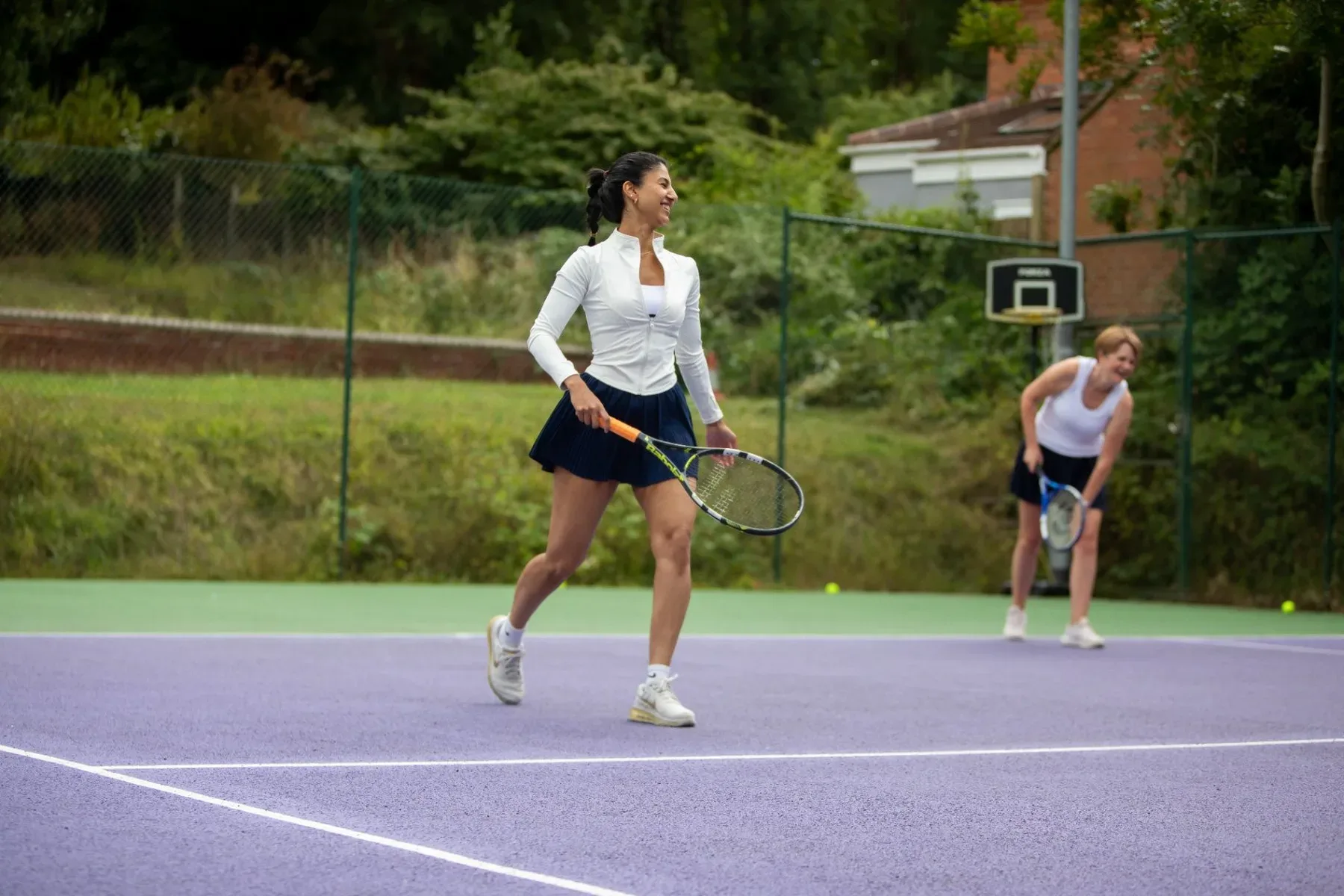 An adult player moving across court during a Feel Great Tennis session