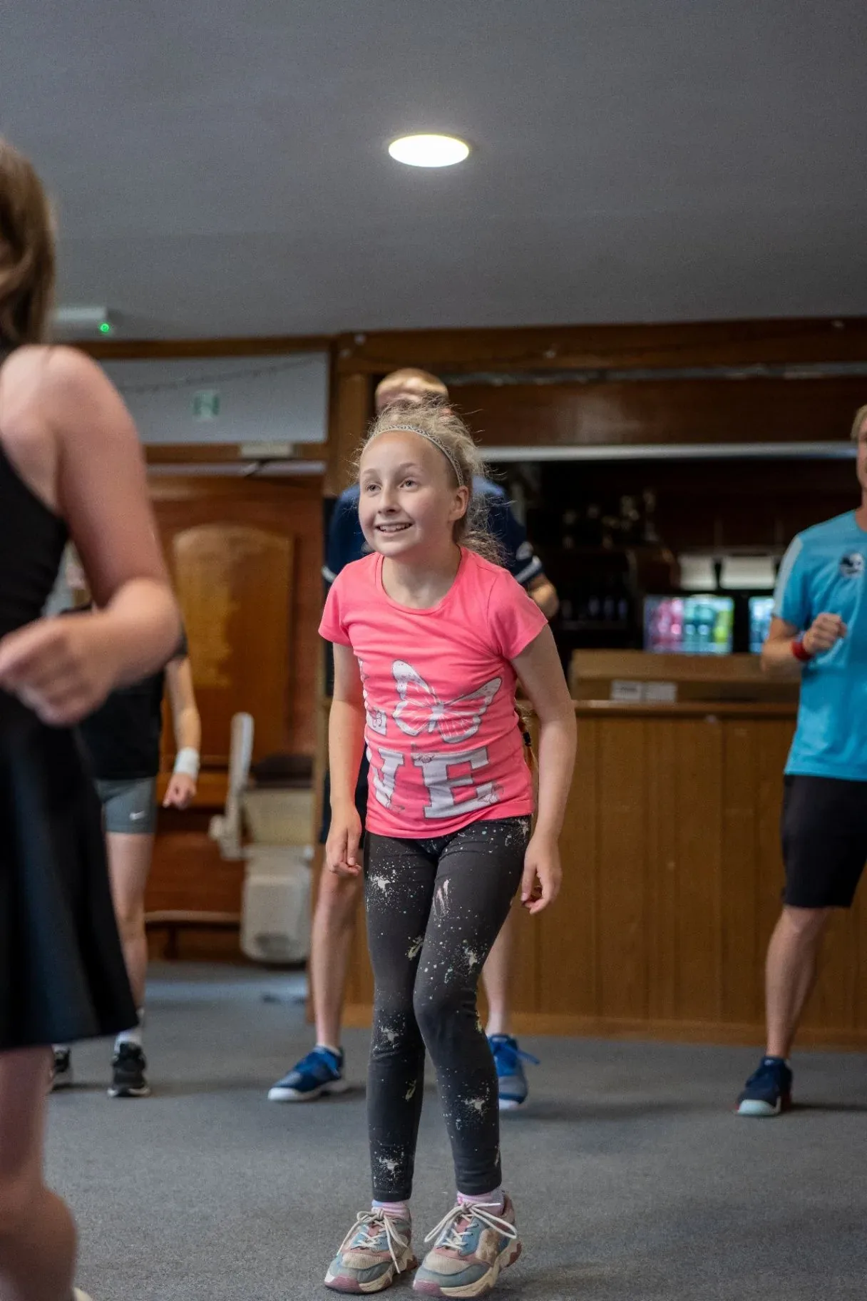 A smiling girl joining in an indoor game in the clubhouse
