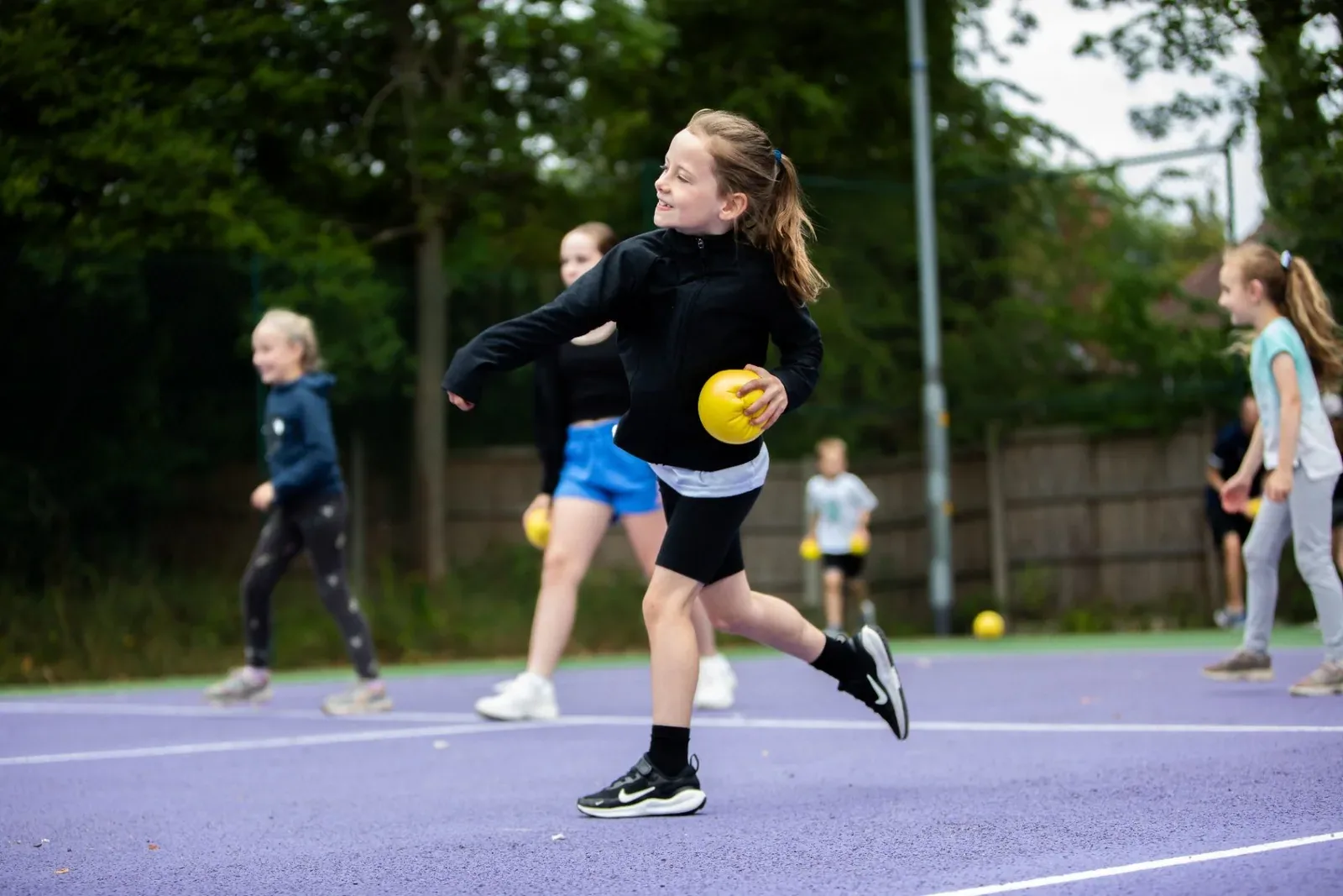 Children playing dodgeball on court at an MH Tennis holiday camp