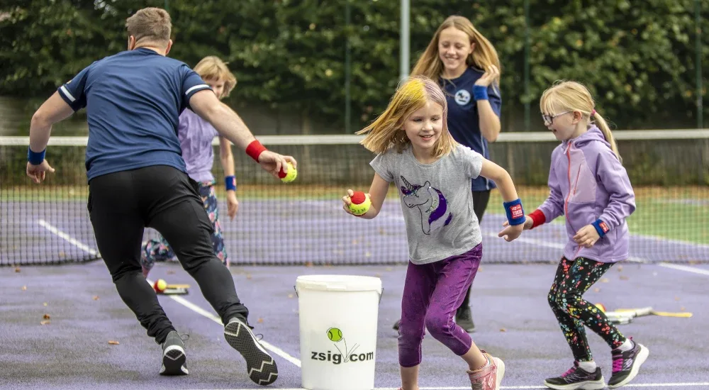 Children racing to collect balls from a bucket in a camp relay game