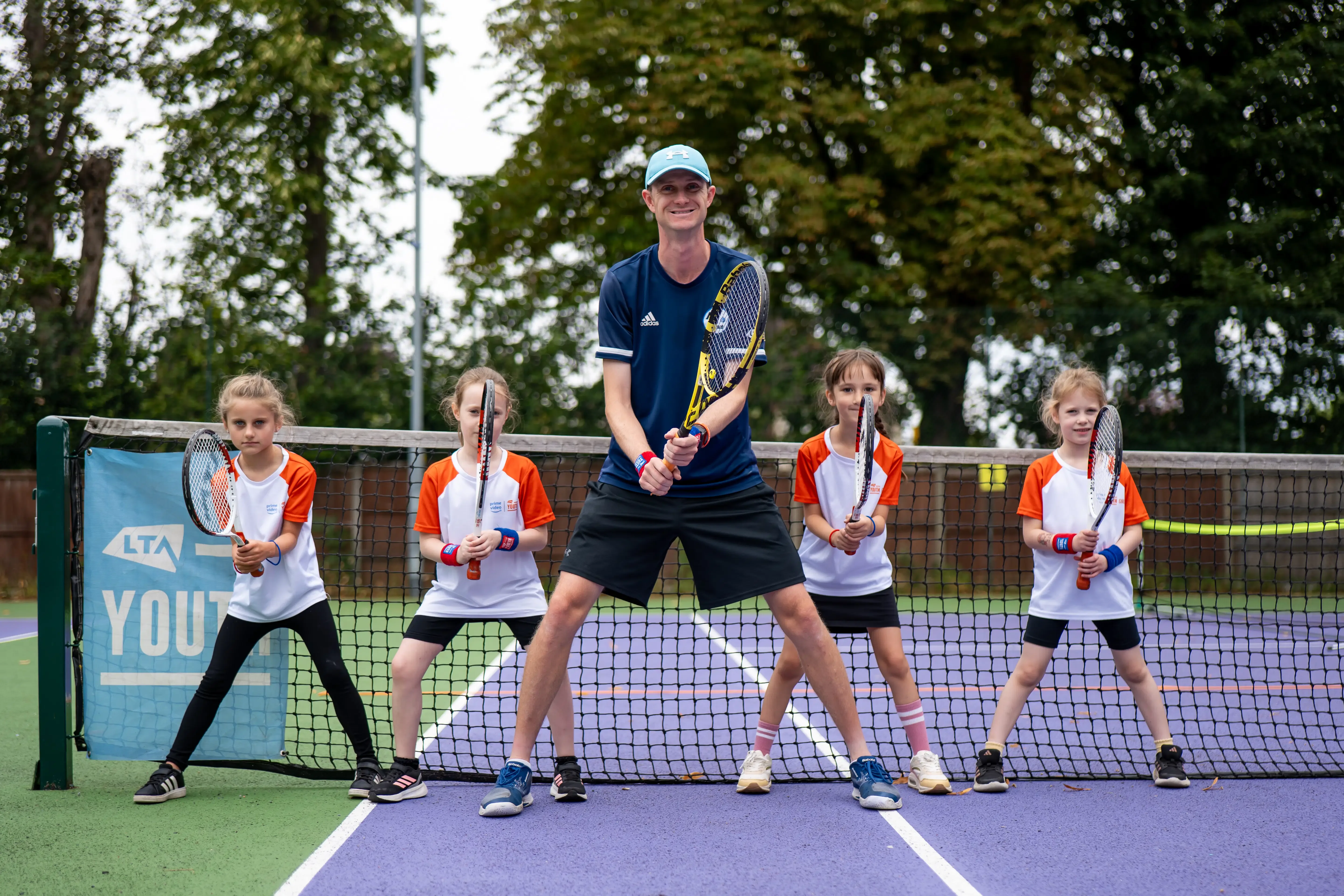 MH Tennis coach supporting young players during an LTA Youth tennis session